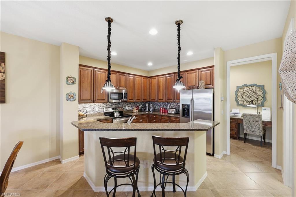 8986 Cambria Circle, Unit 2204 Naples, FL 34113 - Photo 8 of 36 a kitchen with a table and chairs