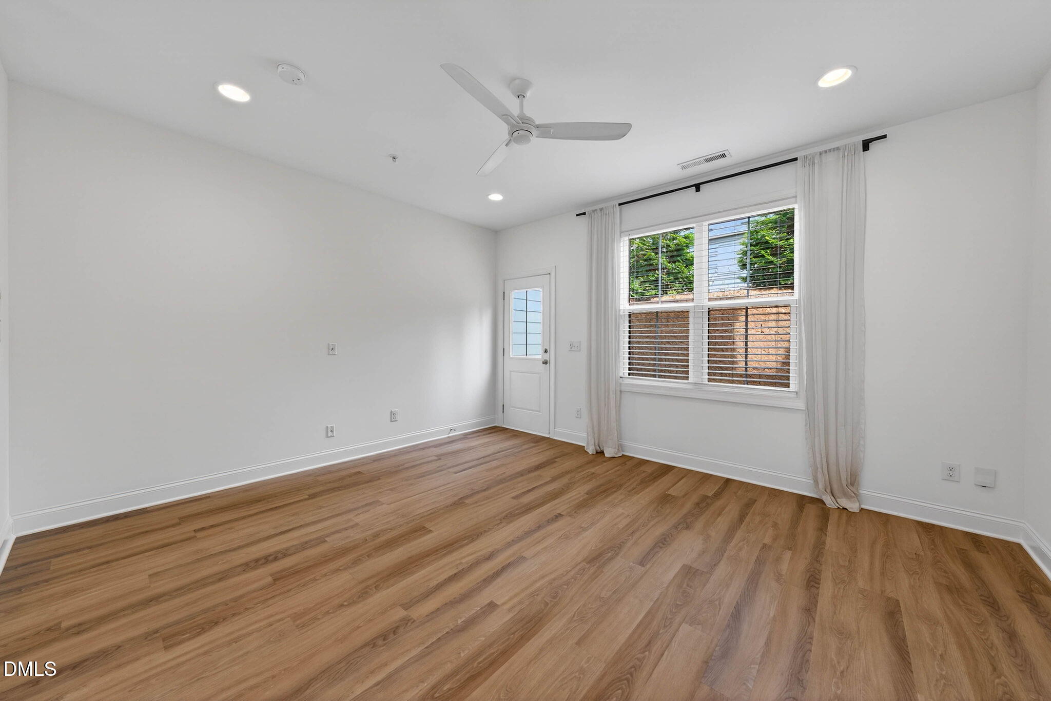 6820 Milligan Way, Unit 104 Raleigh, NC 27613 - Photo 17 of 39 an empty room with wooden floor and windows