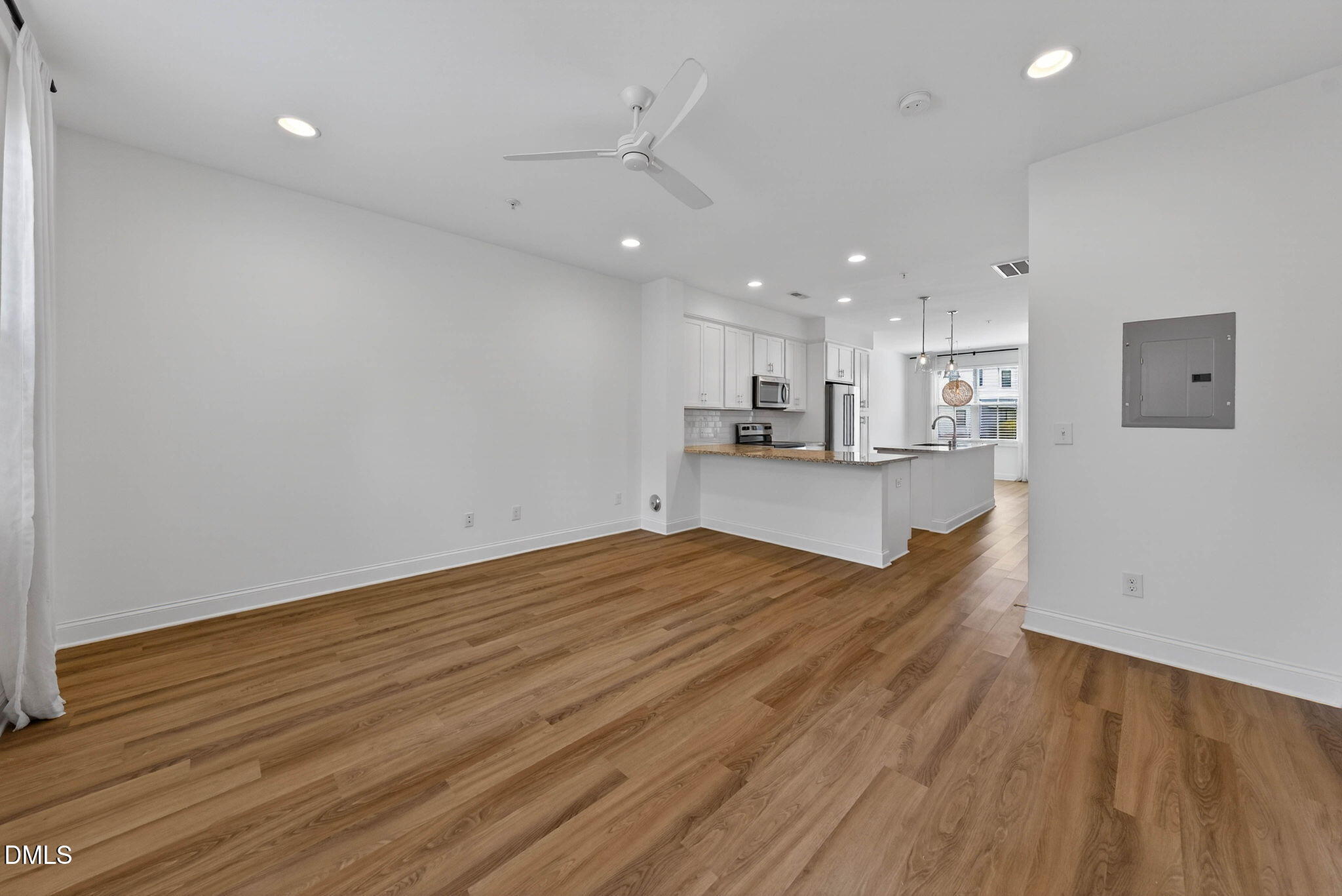 6820 Milligan Way, Unit 104 Raleigh, NC 27613 - Photo 19 of 39 a view of kitchen and empty room with wooden floor