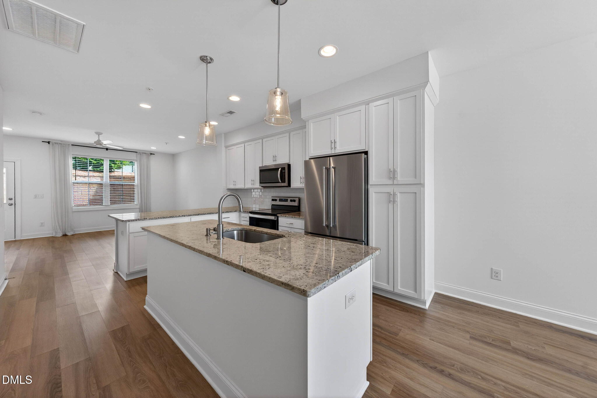 6820 Milligan Way, Unit 104 Raleigh, NC 27613 - Photo 6 of 39 a kitchen with kitchen island a sink appliances and wooden floor