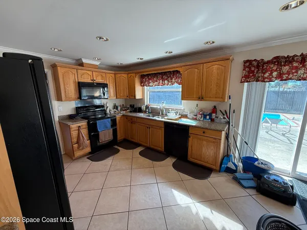 a kitchen with stainless steel appliances a stove a sink a microwave a refrigerator and cabinets