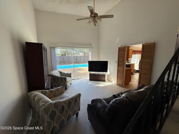 a living room with furniture a flat screen tv and a large window