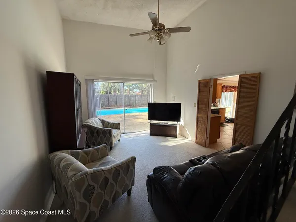 a living room with furniture a flat screen tv and a large window