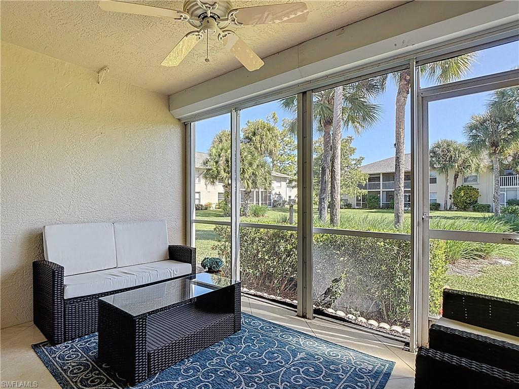 729 Landover Court, Unit 102 Naples, FL 34104 - Photo 18 of 28 a living room with furniture and a floor to ceiling window
