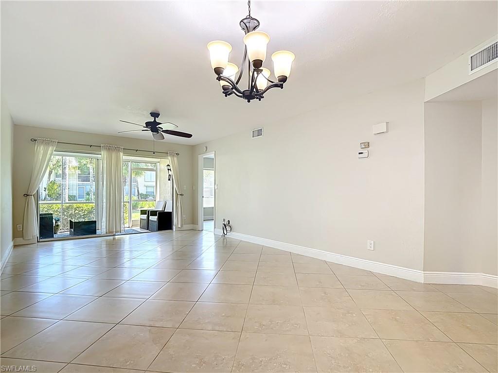 729 Landover Court, Unit 102 Naples, FL 34104 - Photo 7 of 28 a view of an empty room with a chandelier fan and windows