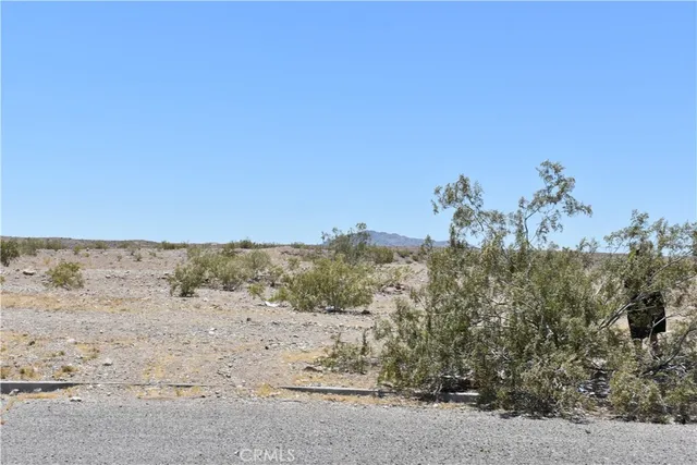 a view of beach and covered with snow in the background