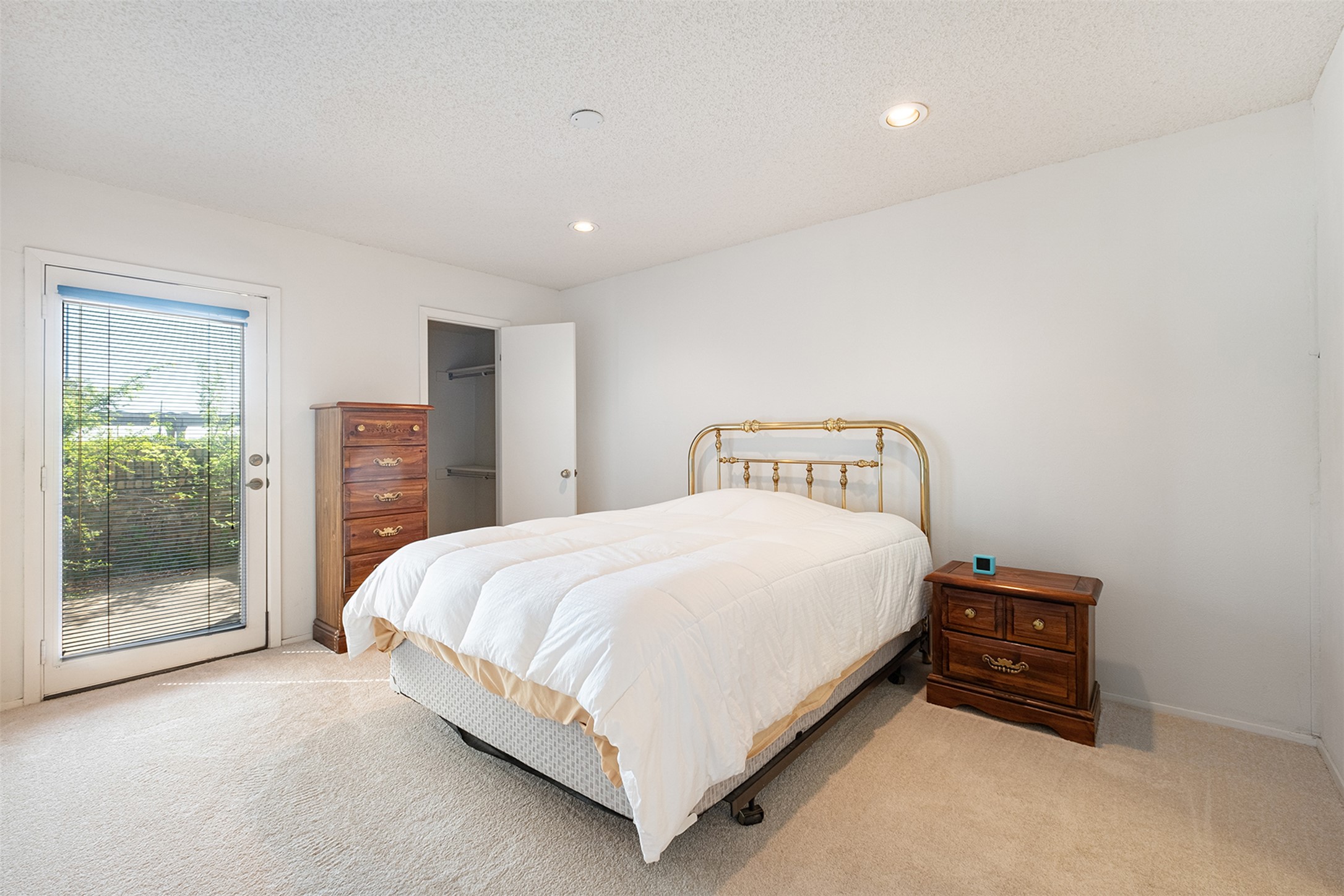 1748 Ohlen Road, Unit 16 Austin, TX 78757 - Photo 18 of 38 Bedroom with light colored carpet, access to outside, recessed lighting, and a textured ceiling