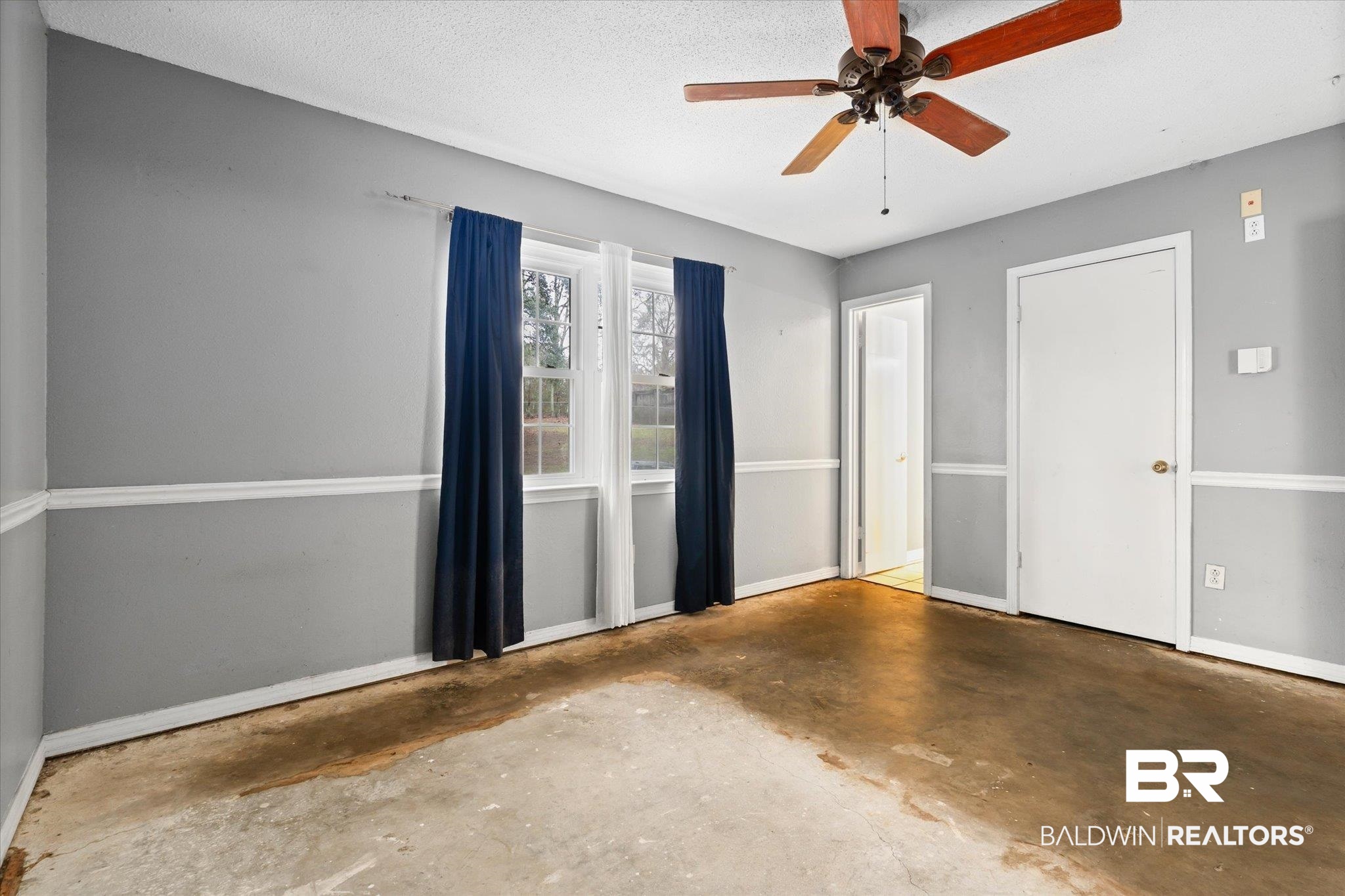 3541 Winston Drive Semmes, AL 36575 - Photo 10 of 20 Empty room with a ceiling fan, unfinished concrete flooring, a textured ceiling, and baseboards