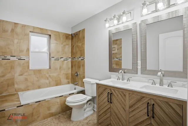 a bathroom with a bathtub shower sink mirror and toilet