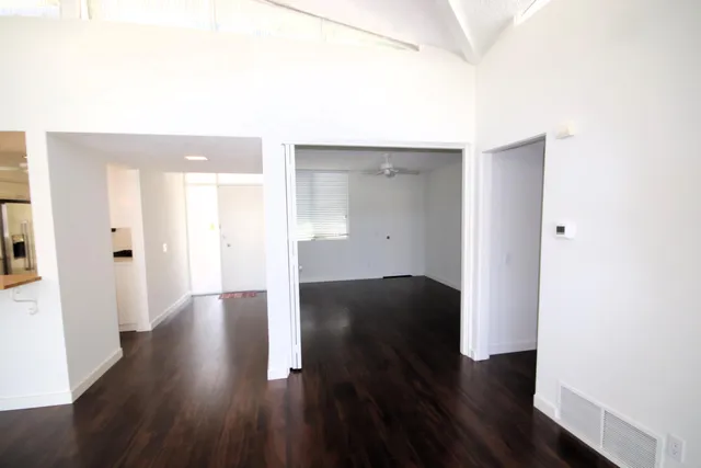 a view of an empty room with wooden floor