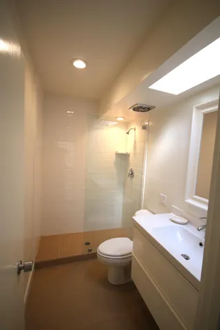 a bathroom with a sink a toilet and shower