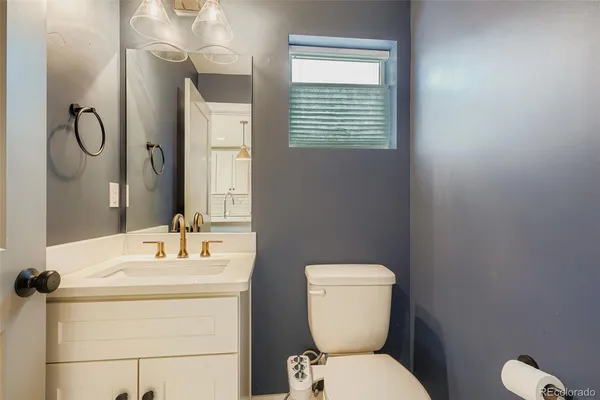 a bathroom with a toilet sink vanity and mirror