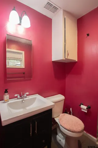 a bathroom with a sink mirror and toilet