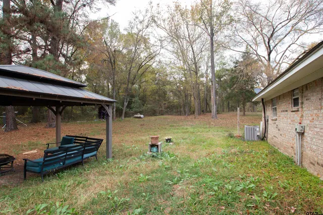 a backyard of a house with barbeque oven and table