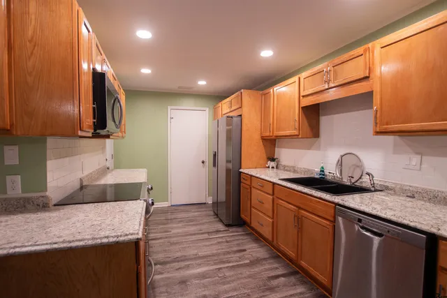 a kitchen with stainless steel appliances granite countertop wooden cabinets a oven and granite counter tops