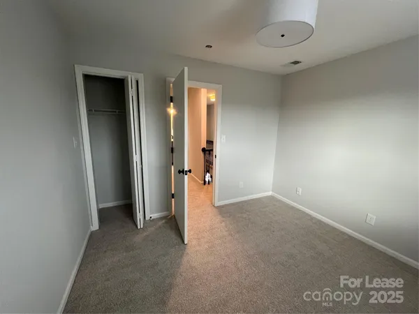 an empty room with closet and a bathroom