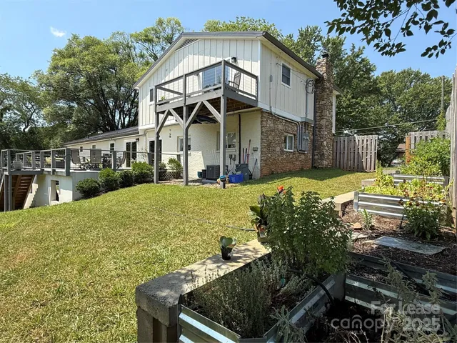 a view of a white house with a yard table and chairs