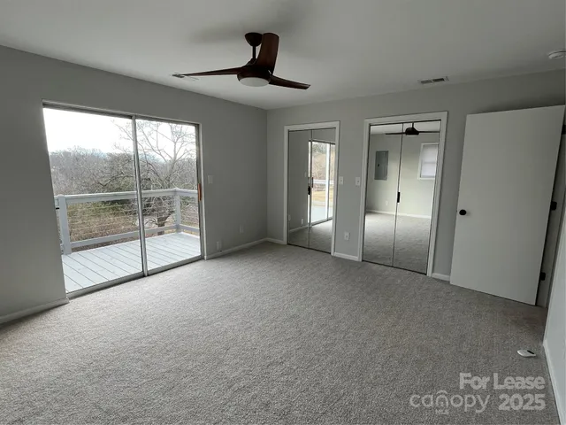 an empty room with windows and cabinet