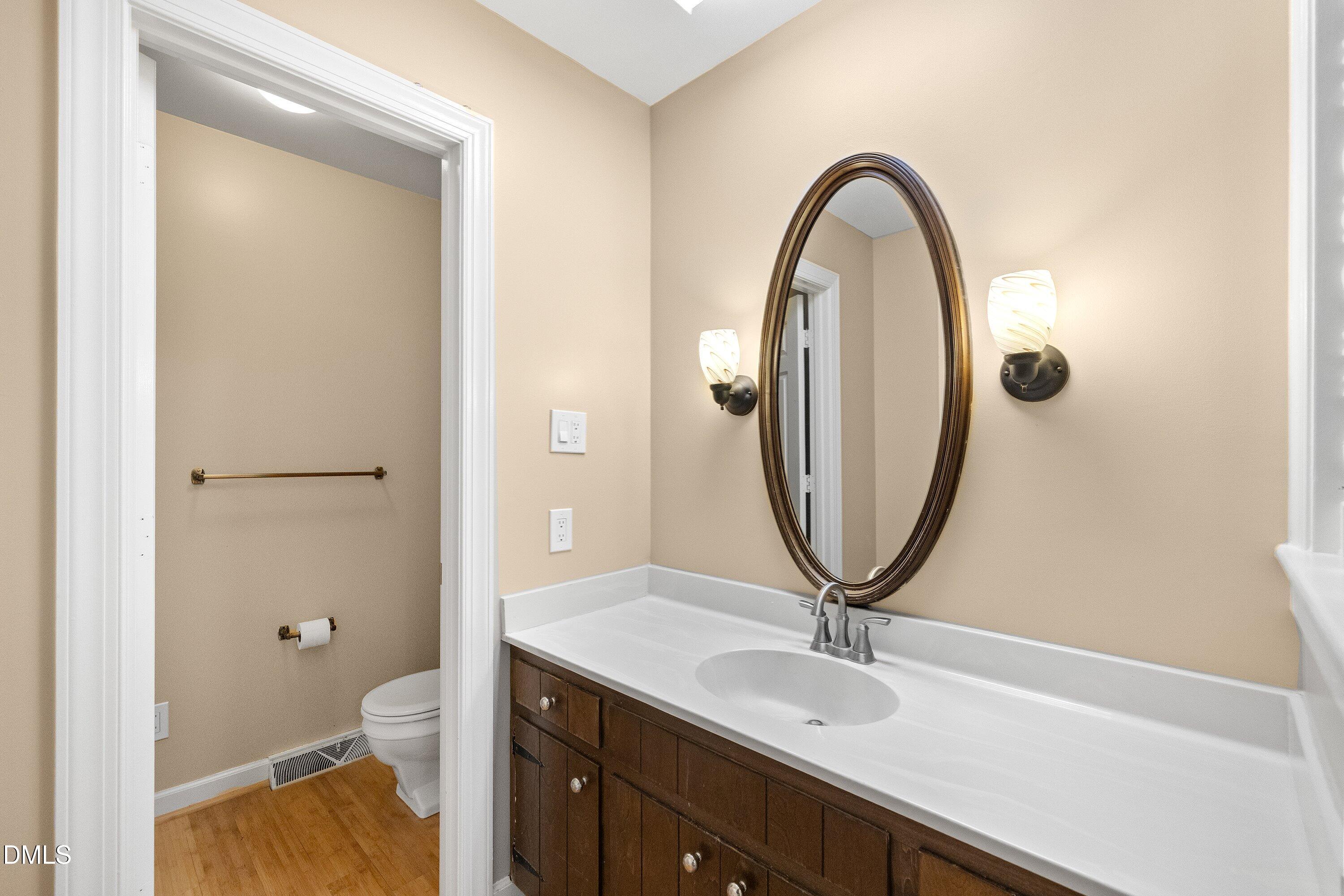 8133 Holly Forest Road Wake Forest, NC 27587 - Photo 35 of 50 a bathroom with a granite countertop toilet a sink and a mirror