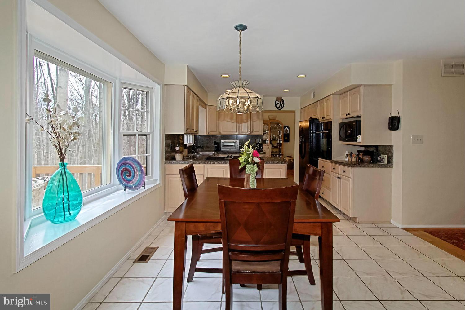 10714 Cross School Road Reston, VA 20191 - Photo 9 of 27 a view of a dining room and livingroom with furniture wooden floor a chandelier