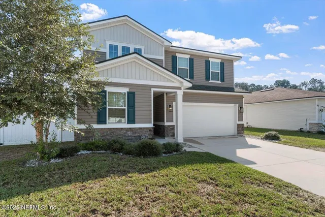 a front view of a house with a yard and garage