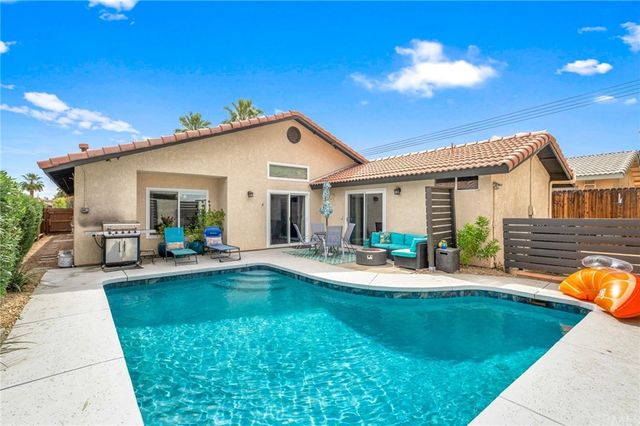 a view of a house with backyard and sitting area