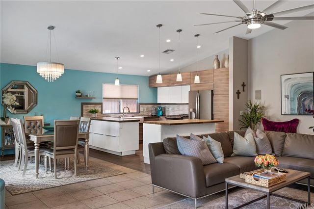 a living room with furniture a dining table and a chandelier