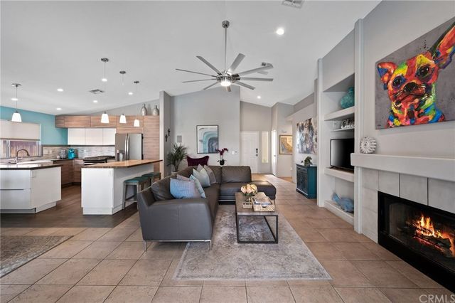 a living room with furniture a fireplace and a chandelier