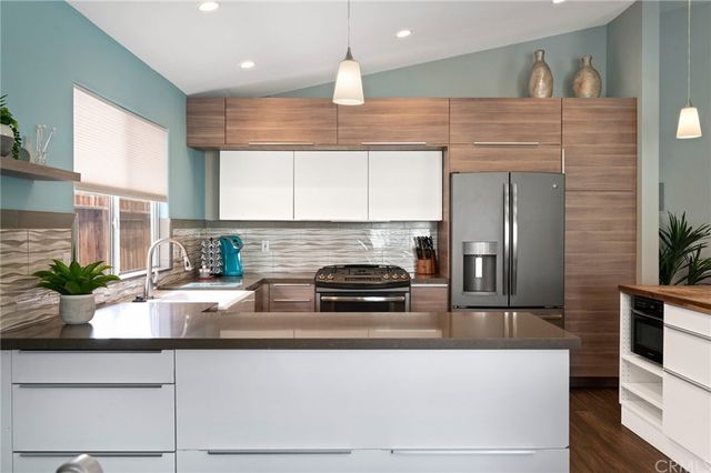 a kitchen with stainless steel appliances a sink a stove top oven a counter space and cabinets