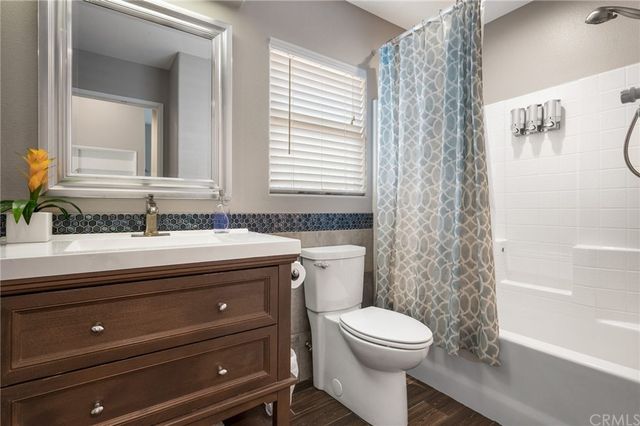 a bathroom with a granite countertop toilet a sink a mirror and a shower