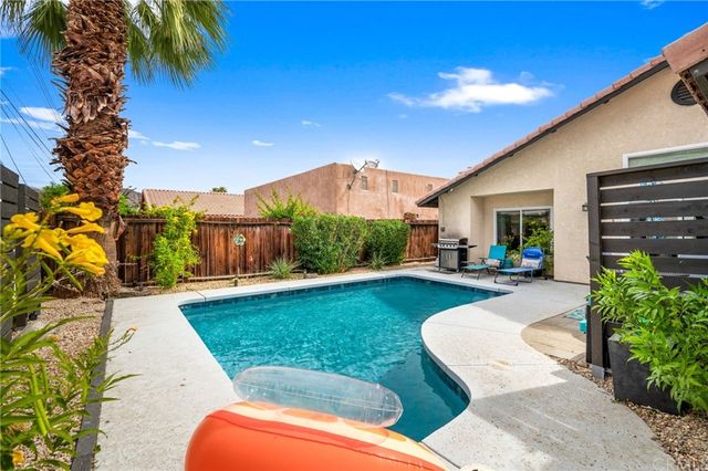 a view of a patio with couches plants and large tree