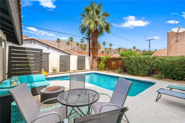 a view of a patio with couches table and chairs with potted plants