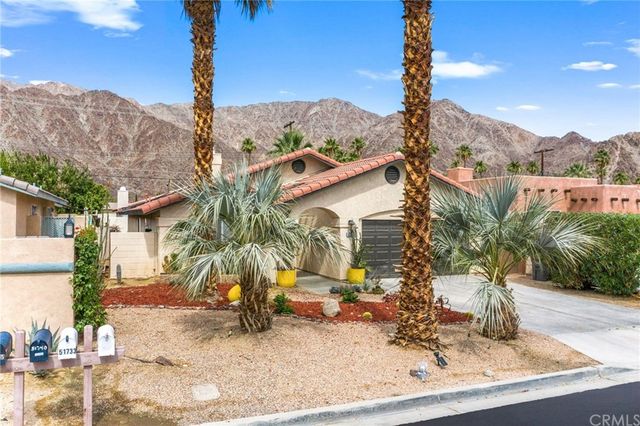 a view of a house with a yard and sitting area