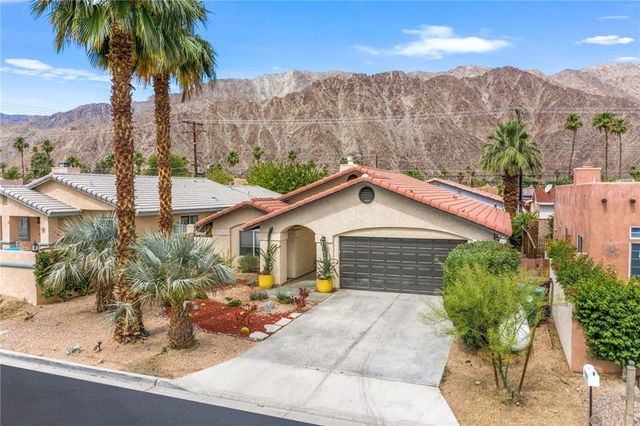 a front view of a house with yard and mountain view