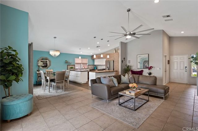 a living room with furniture a chandelier and a dining table