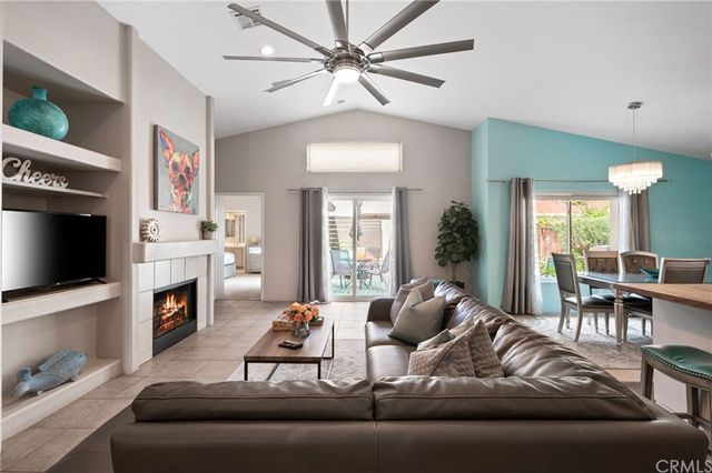 a living room with furniture a flat screen tv and a fireplace