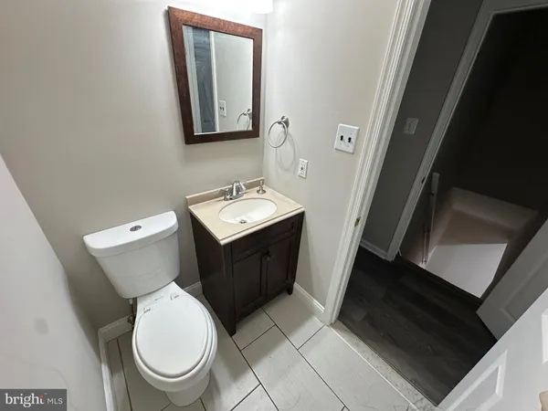 a bathroom with a toilet a sink and mirror
