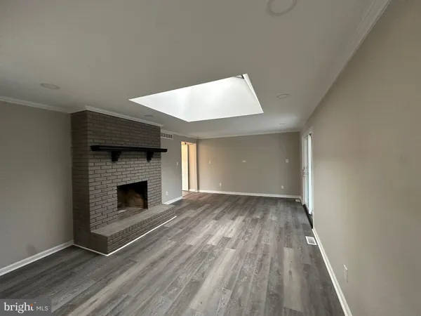 a view of empty room with wooden floor and fireplace