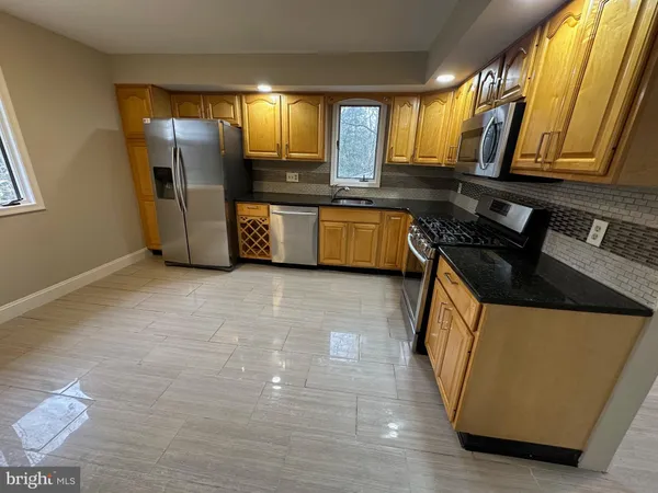 a kitchen with stainless steel appliances a refrigerator a sink a stove and cabinets