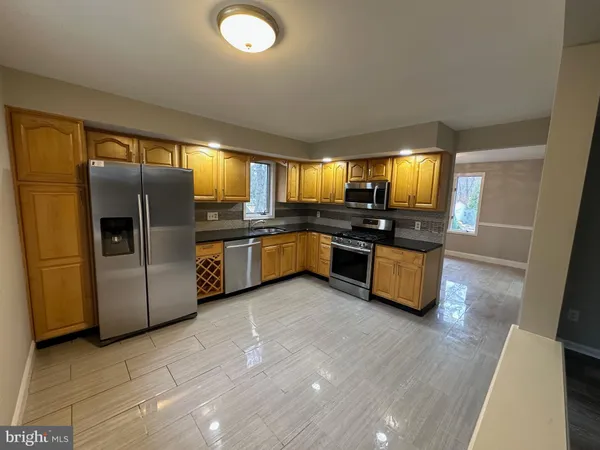 a kitchen with stainless steel appliances a refrigerator a sink a stove a microwave a counter top space and cabinets