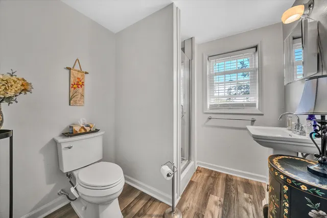 a bathroom with a sink a toilet and a window