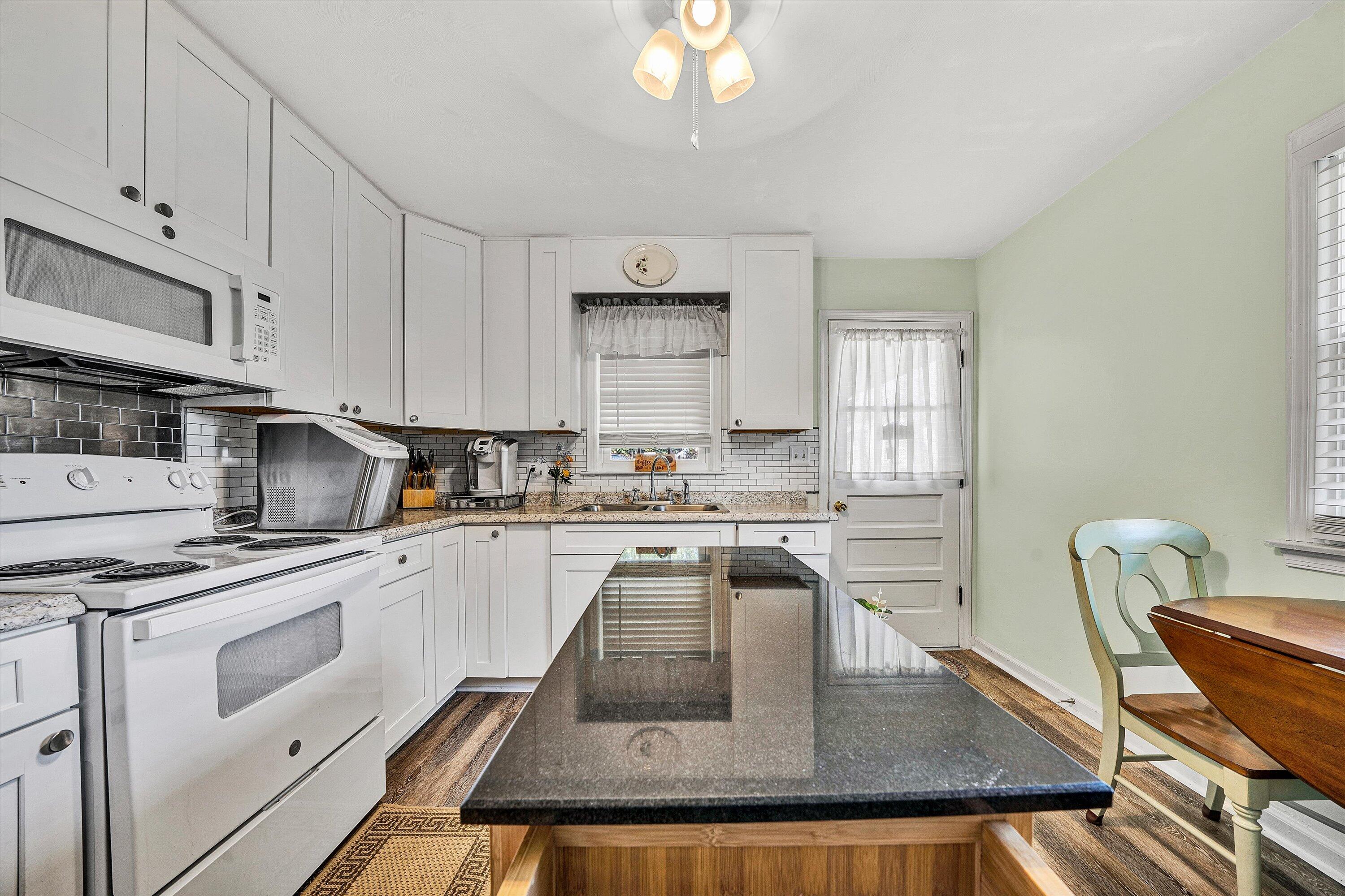 3876 Shingle Block Road Bedford, VA 24523 - Photo 8 of 29 a kitchen with kitchen island granite countertop a stove a sink and white cabinets