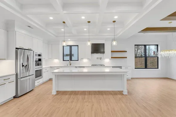 a kitchen with stainless steel appliances granite countertop wooden floors and white cabinets