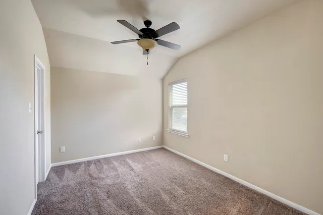 an empty room with a window and a fan