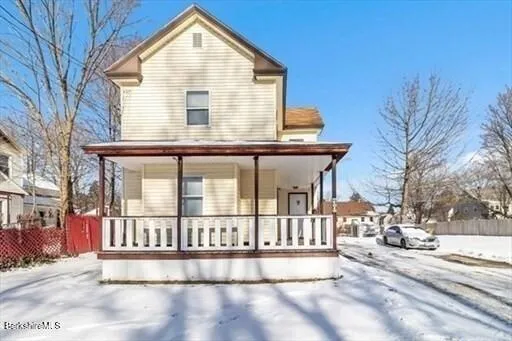 a view of a white house with large windows and a small yard
