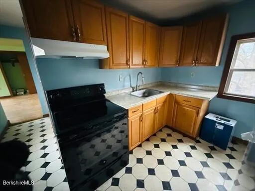 a kitchen with a sink a stove and cabinets