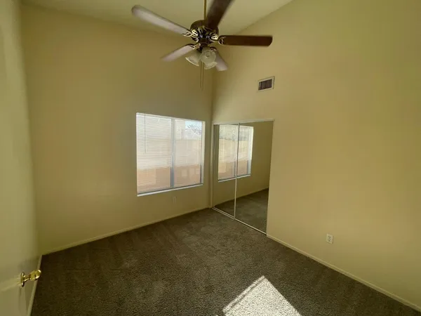 an empty room with a window and a fan