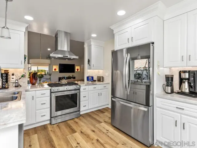 a kitchen with stainless steel appliances a stove a refrigerator and a fireplace