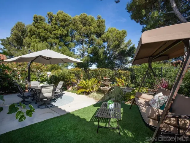 a view of a patio with table and chairs potted plants with large tree