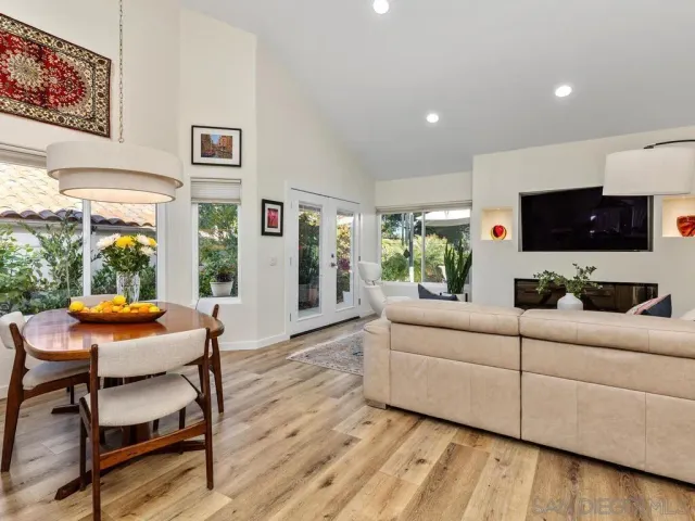 a living room with furniture a flat screen tv and a large window